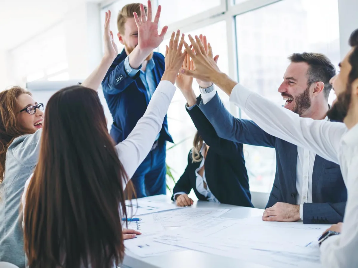 Real estate professionals celebrating together in a bright office